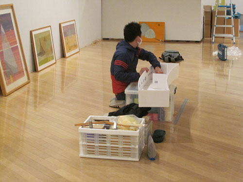 2:模型と展示室を交互にみながら、作品の配置を確認中。